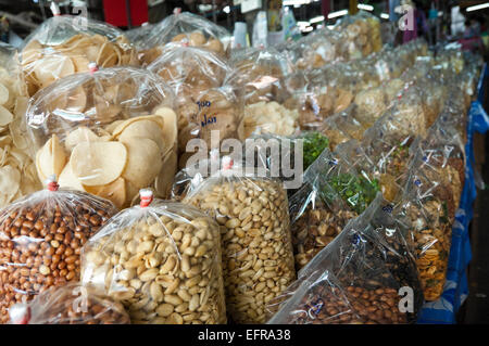 Horizontal close up of rows of plastic bags full of nuts and dried snacks in Thailand. Stock Photo