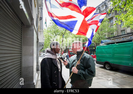 Brustchom Ziamani (L) pictured here 9th May 2014 outside the Indian High Commission in London being confronted by Paul Golding (R) of Britain First Nationalist movement.  Brustchom Ziamani, 19, has been remanded in custody after appearing in court to face terror allegations. Ziamani, of Camberwell, south-east London, has been accused of 'engaging in conduct in preparation of terrorist acts' on or before 19th August 2014. Mr Ziamani was arrested in east London on Tuesday 19th Aug 2014. He is currently on trial at Old Bailey court. Stock Photo