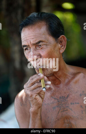 Mulberry (saa) paper artisan smoking a cigar, near Chiang Mai, Thailand Stock Photo