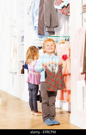 Boy with vest on hanger and girl choosing  clothes Stock Photo