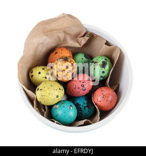 Quail eggs in the wrapping paper in a ceramic bowl on a white background. Isolated with clipping path. Top view. Stock Photo