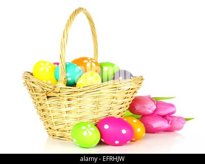 Easter basket filled with colorful eggs over a white background Stock Photo