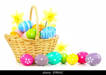 Easter basket filled with colorful eggs on a white background Stock Photo