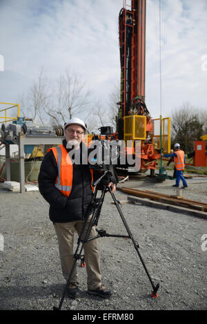 A documentary filmmaker poses with his camera on location at an oil rig in New Zealand Stock Photo