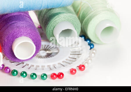 Sewing strings and needles on a light background Stock Photo