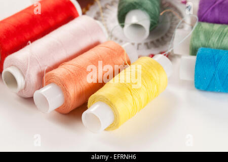 Sewing strings and needles on a light background Stock Photo