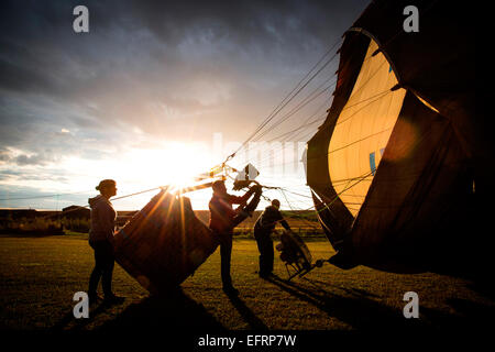 Crew inflating hot air balloon at sunset, South Oxfordshire, England Stock Photo