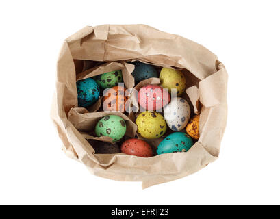 Colored quail eggs in a paper bag on a white background. Isolated with clipping path Top view. Stock Photo