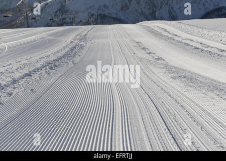 Fresh snow groomer tracks on a ski piste in the dolomites Stock Photo