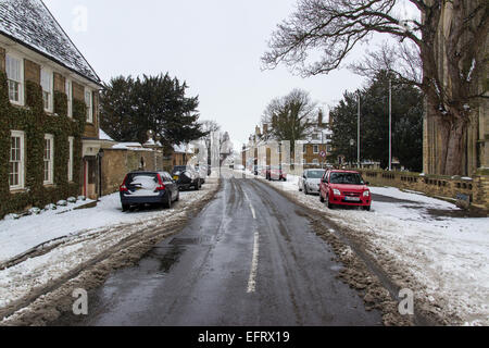 Thorney Abbey in the snow Whittlesea Road Thorney in the winter Thorney church place of worship cars and street in the snow Stock Photo