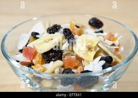 Close up of dried fruit, nut and coconut, or trail mix, in glass bowl Stock Photo