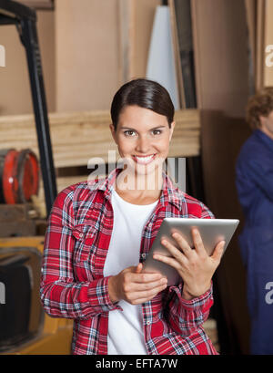 Confident Female Supervisor Holding Digital Tablet Stock Photo