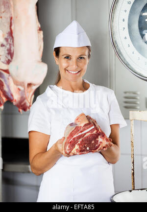 Confident Female Butcher Holding Fresh Meat Stock Photo
