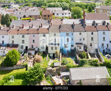 Colourful sunlit row of terraced houses showing their rear gardens in Chepstow, Wales seen from a high viewpoint on Chepstow Castle Stock Photo