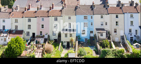 Colourful sunlit row of terraced houses showing their rear gardens in Chepstow, Wales seen from a high viewpoint on Chepstow Castle Stock Photo