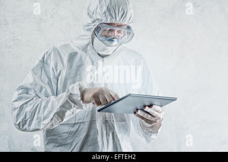Chemical Scientist in Protective Laboratory Clothing Using Digital Tablet Computer Stock Photo
