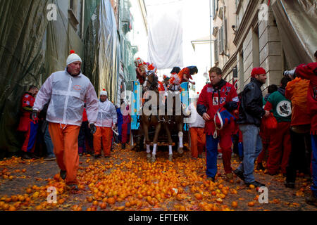 An horse cart passes through the narrow streets of the ancient city of Ivrea during the Battle of the Oranges. Stock Photo