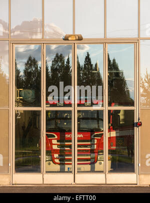 Fire truck behind glass doors at fire station garage , Finland Stock Photo