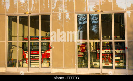 Fire trucks behind glass doors at fire station garage , Finland Stock Photo