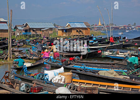 Open boats at lakeside village with traditional wooden houses on stilts in Inle Lake, Nyaungshwe, Shan State, Myanmar / Burma Stock Photo