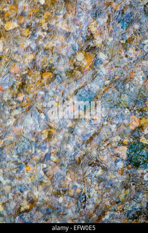 Overhead detail of shallow river water flowing over shingle river bed Stock Photo