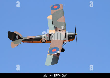 De Havilland Tiger Moth vintage biplane aircraft in the colours of a Royal Air Force World War II training plane flying in the air against a blue sky Stock Photo