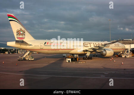 Etihad Airways Boeing 777-300ER long haul widebody passenger jet plane parked on the ramp at Manchester Airport, UK Stock Photo