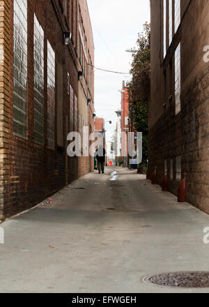 Man walking in back alley - USA Stock Photo