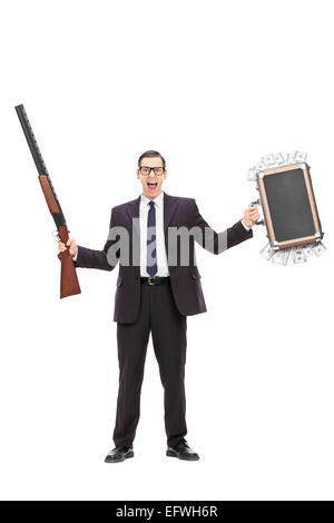 Full length portrait of an angry businessman holding a rifle and a bag full of money isolated on white background Stock Photo