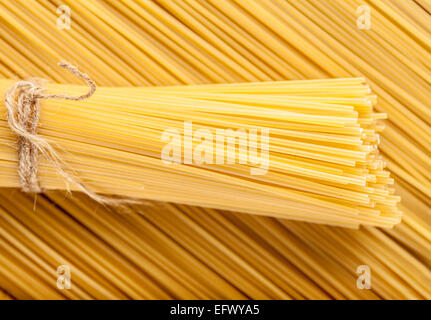 yellow background the raw pasta tied rope Stock Photo