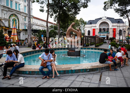 People sitting outside Vincom Center shopping mall, Ho Chi Minh City (Saigon), Vietnam. Stock Photo