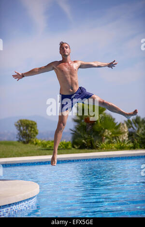 Young man jumping in the pool Stock Photo