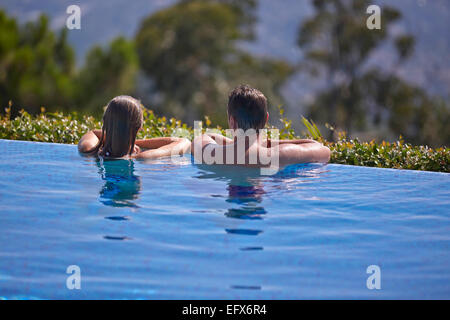 Couple on holiday in infinity pool in the South of France looking at the Cote d'Azur view Stock Photo