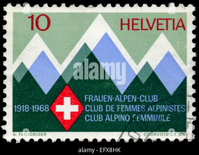 SWITZERLAND - CIRCA 1968: a stamp printed in the Switzerland shows Mountains and Emblem of the Swiss Women's Alpine Club, 50th A Stock Photo