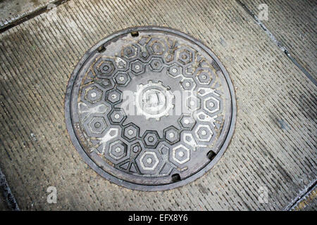 A  cast iron manhole cover in Brooklyn in New York with the vintage Bell System (Ma Bell) logo, ca. 1969, seen on Saturday, February 7, 2015. The Bell Telephone Company, which became AT&T, was broken up in 1984 into independent companies.  (© Richard B. Levine) Stock Photo