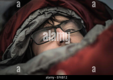 Portrait of young male camper in hooded sleeping bag, Bavarian Alps, Oberstdorf, Bavaria, Germany Stock Photo