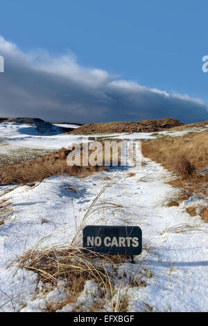 no carts sign on a snow covered links golf course in ireland in snowy winter weather Stock Photo