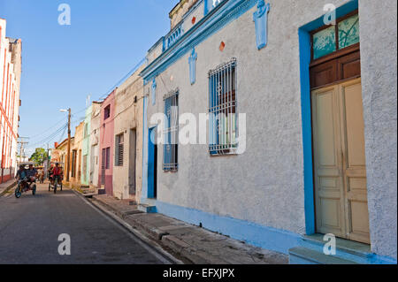 Horizontal view of bicitaxis riding through the streets in Camaguey, Cuba. Stock Photo