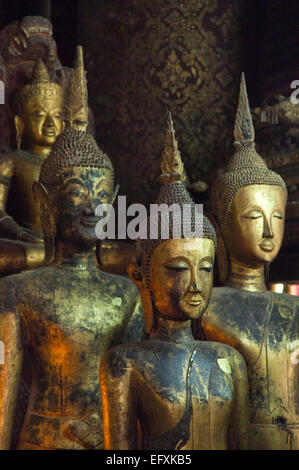 Vertical close up of various Buddhas at the altar at Wat Mai Suwannaphumaham or New Monastery in Luang Prabang. Stock Photo