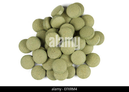 A pile of nutritional supplement with spirulina (green algae) C-vitamin tablets / pills. Isolated on white background. Stock Photo