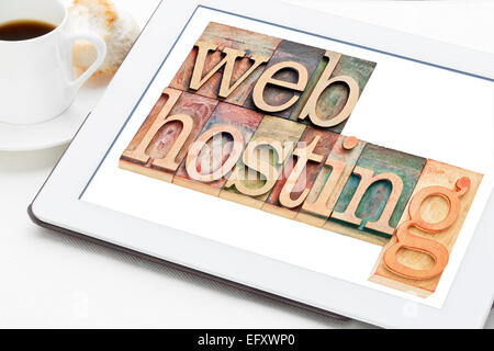 web hosting concept - text in letterpress wood type blocks on a digital tablet with a cup of coffee Stock Photo