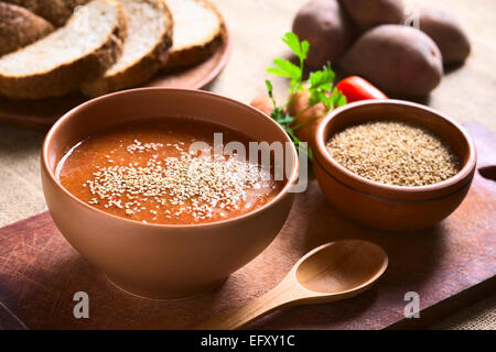 Cream of vegatable soup made of tomato, carrot, potato and parsley served in bowl and sprinkled with sesame seeds Stock Photo