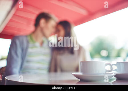 Porcelain cup with saucer on background of romantic couple Stock Photo