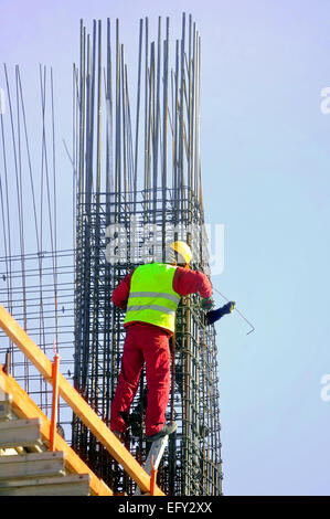 Two construction workers knitting steel rods reinforcement for concrete pouring Stock Photo
