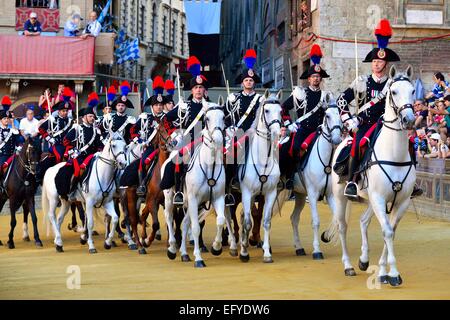 Mounted dragoons at a parade before the historical horse race Palio di Siena, Piazza del Campo, Siena, Tuscany, Italy Stock Photo