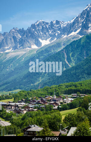 Les Houches ski resort village with the Aiguilles de Chamonix range behind, Chamonix Valley, France, Europe Stock Photo