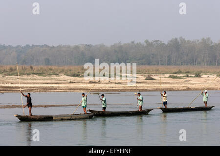 Nepalese men in dugouts on the East Rapti River at Sauraha, Nepal Stock Photo