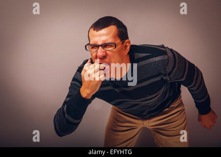 the man of European appearance brunet in a sweater put his finge Stock Photo