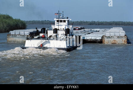 A powerful type of towboat called a pusher, pusher boat or pusher tug pushes full and empty cargo barges up the lengthy Mississippi River in the USA. Stock Photo