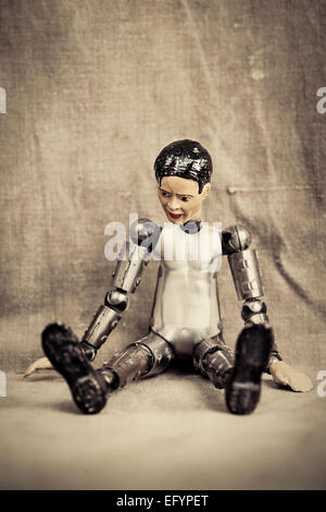 Pensive and depressed male toy doll sitting and looking down. Old fashioned retro design. Stock Photo